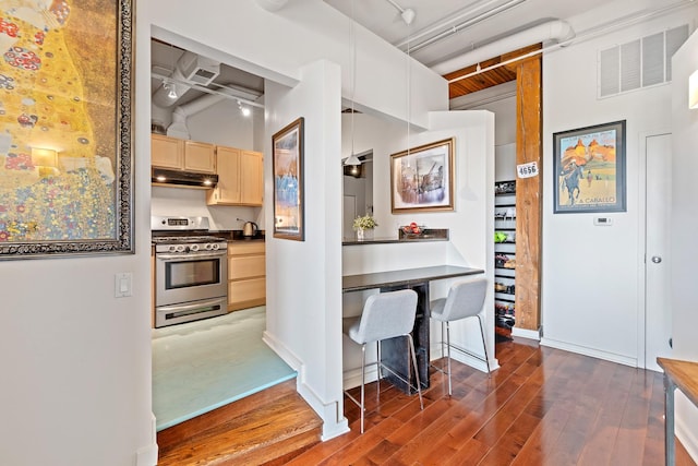 1725 W N Ave Unit 404, Chicago, IL 60622 - kitchen featuring gas stove, light brown cabinets, under cabinet range hood, wood finished floors, and beamed ceiling