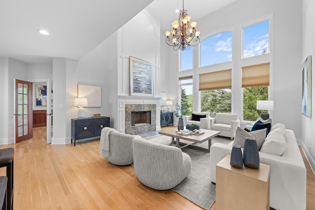 1410 W Newcastle Ct, Inverness, IL 60010 - living area featuring a chandelier, light wood-type flooring, a premium fireplace, a towering ceiling, and baseboards