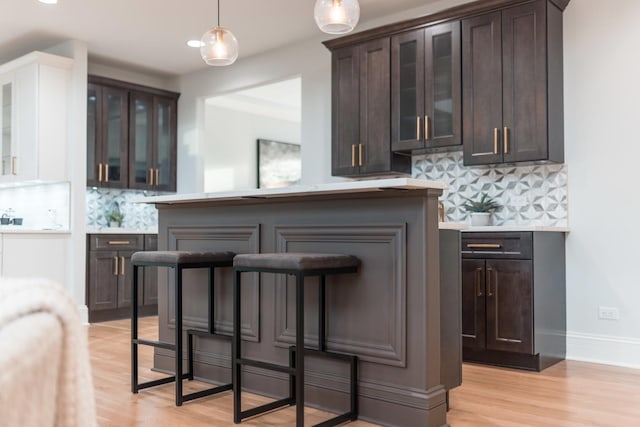 1410 W Newcastle Ct, Inverness, IL 60010 - bar area featuring backsplash, light wood-type flooring, decorative light fixtures, and baseboards