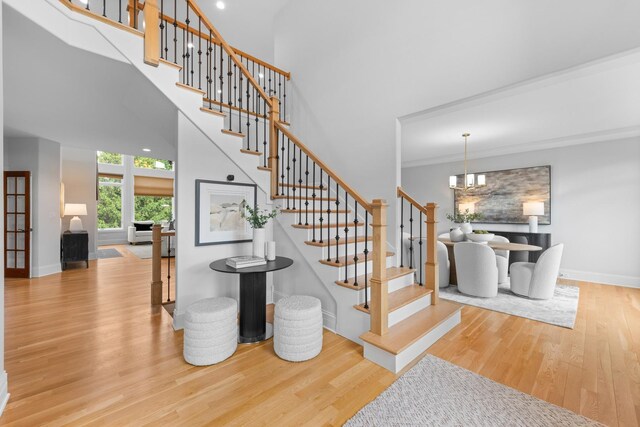 1410 W Newcastle Ct, Inverness, IL 60010 - staircase with wood finished floors, a towering ceiling, baseboards, a chandelier, and crown molding