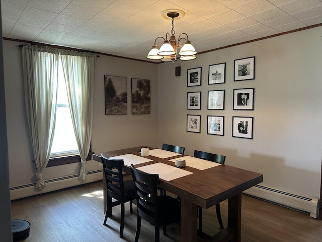 dining space featuring a baseboard heating unit, wood finished floors, a chandelier, healthy amount of natural light, and ornamental molding