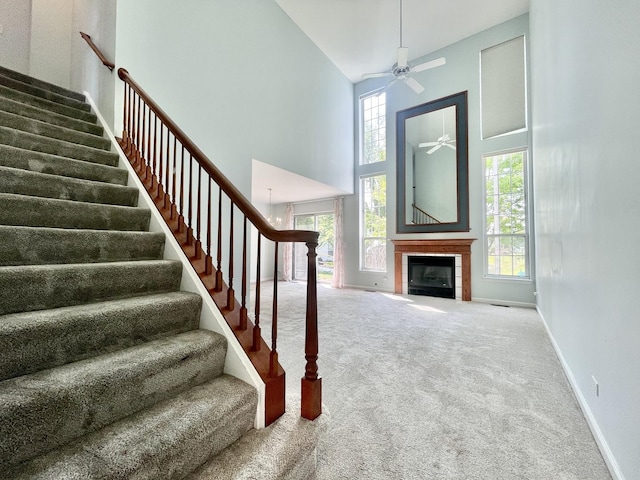 103 Hemstead St Unit 34-D, Lake Bluff, IL 60044 - stairway with a high ceiling, ceiling fan, carpet, a tiled fireplace, and baseboards