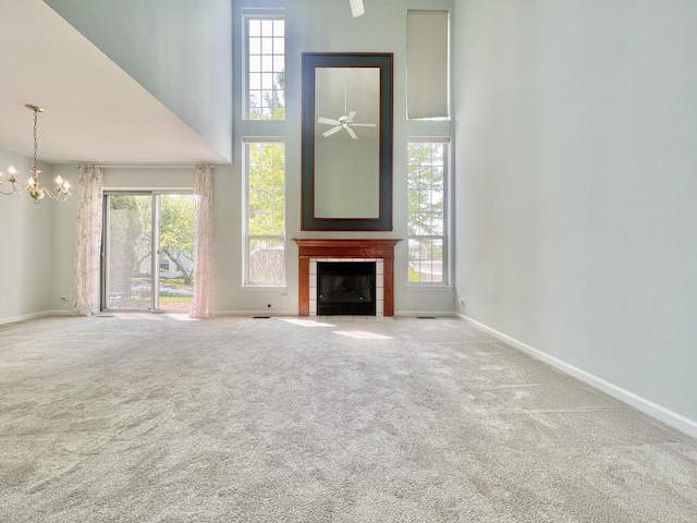 103 Hemstead St Unit 34-D, Lake Bluff, IL 60044 - unfurnished living room featuring a towering ceiling, a chandelier, a tiled fireplace, and healthy amount of natural light