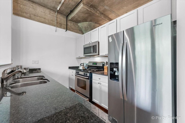 1001 W 15th St Unit 243, Chicago, IL 60608 - kitchen featuring appliances with stainless steel finishes, a sink, white cabinetry, and dark stone counters