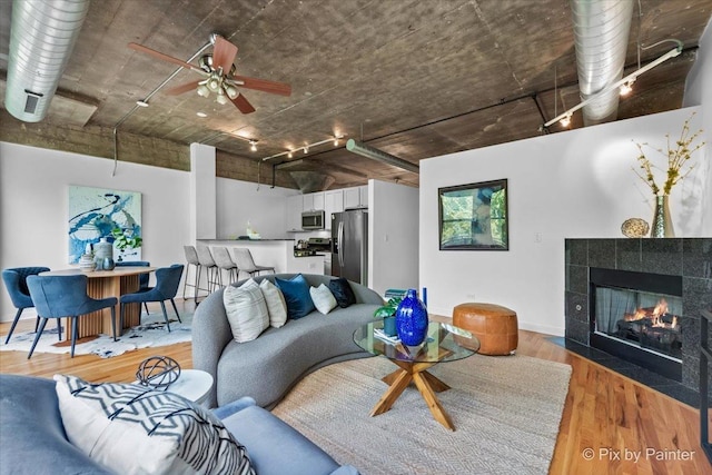 1001 W 15th St Unit 243, Chicago, IL 60608 - living area featuring light wood finished floors, track lighting, ceiling fan, a tiled fireplace, and baseboards