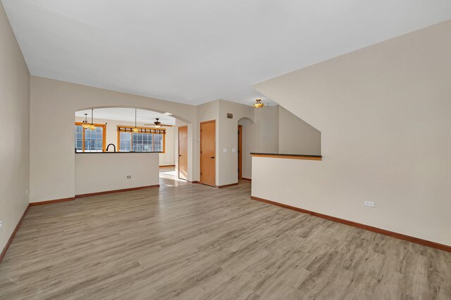 15810 Scotsglen Rd, Orland Park, IL 60462 - unfurnished living room featuring arched walkways, wood finished floors, and a chandelier