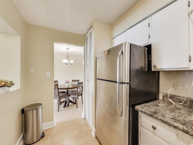 6660 S Brainard Ave Unit 103, Countryside, IL 60525 - kitchen featuring freestanding refrigerator, decorative backsplash, white cabinets, and a chandelier