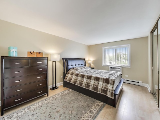 6660 S Brainard Ave Unit 103, Countryside, IL 60525 - bedroom featuring baseboard heating, baseboards, light wood-style floors, and a wall mounted AC