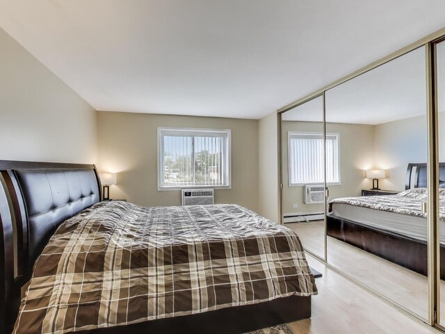 6660 S Brainard Ave Unit 103, Countryside, IL 60525 - bedroom with a closet, a baseboard heating unit, and an AC wall unit
