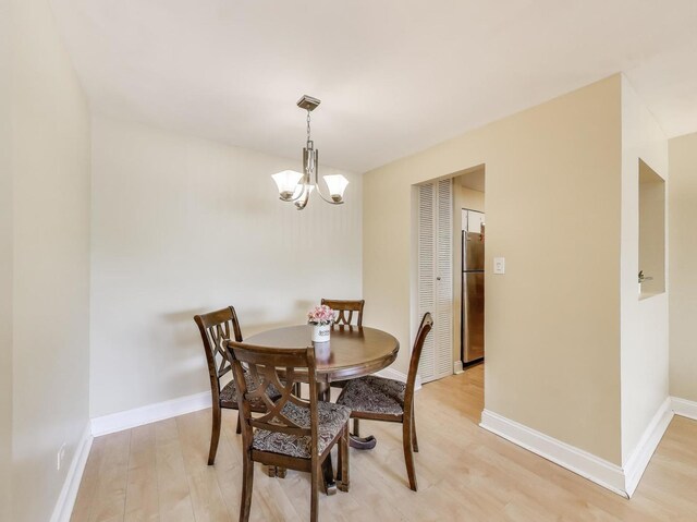 6660 S Brainard Ave Unit 103, Countryside, IL 60525 - dining room with a chandelier, light wood-style flooring, and baseboards