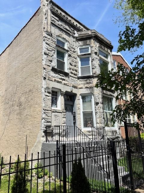 3320 W Monroe St, Chicago, IL 60624 - view of front facade with a fenced front yard and stone siding