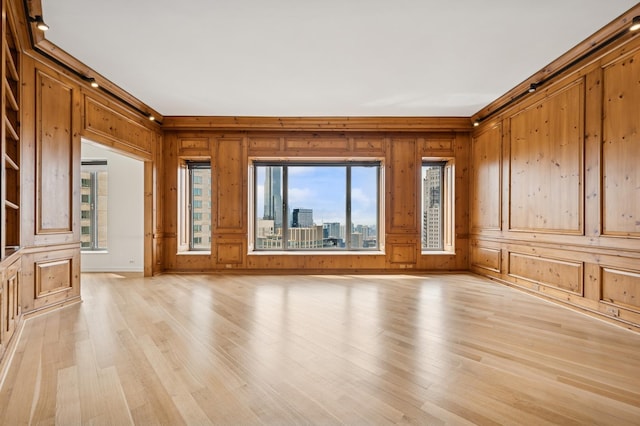 unfurnished living room featuring wood walls and light wood-style flooring
