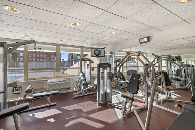 workout area featuring a paneled ceiling and a wall mounted AC