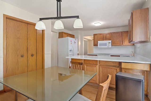 959 Campbell Dr, Naperville, IL 60563 - kitchen with white appliances, a peninsula, wood finished floors, brown cabinets, and light countertops