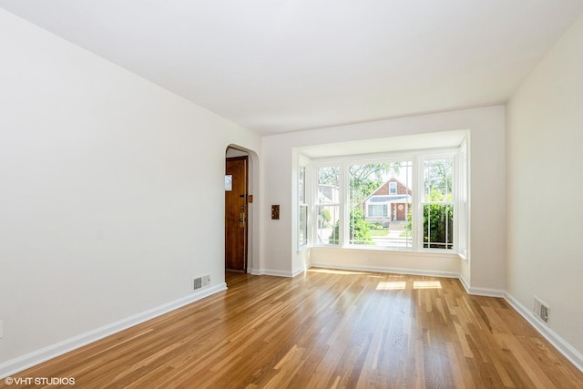 2852 W 84th Pl, Chicago, IL 60652 - unfurnished room featuring arched walkways, light wood-style floors, and baseboards