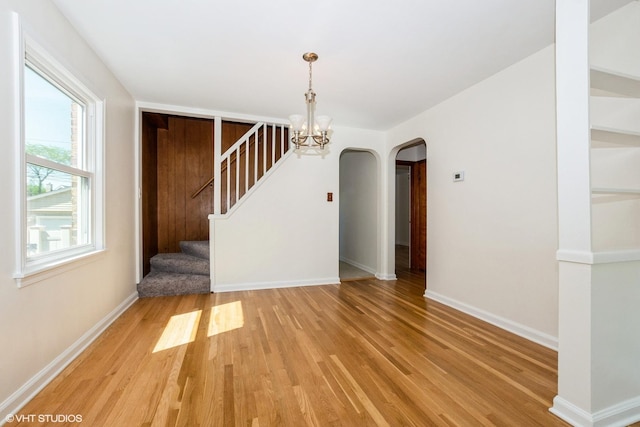 2852 W 84th Pl, Chicago, IL 60652 - unfurnished dining area with light wood-type flooring, arched walkways, a chandelier, and baseboards