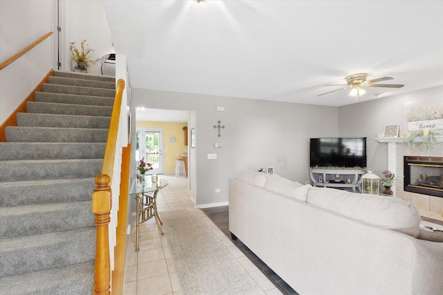 2697 Creekside Ln, Morris, IL 60450 - tiled living room featuring stairway, ceiling fan, a tiled fireplace, and baseboards