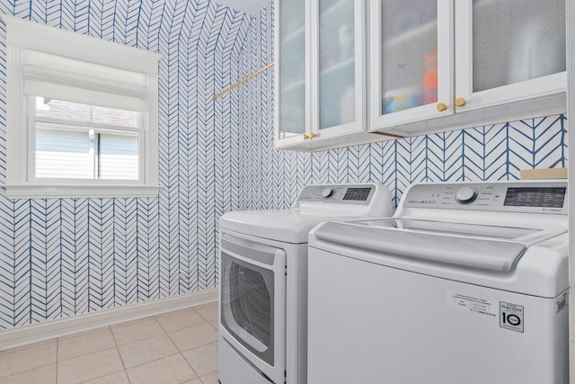 1100 Forest Ave, Wilmette, IL 60091 - clothes washing area featuring wallpapered walls, cabinet space, separate washer and dryer, light tile patterned floors, and baseboards