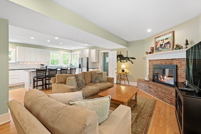 1040 Shermer Rd, Northbrook, IL 60062 - living area featuring recessed lighting, light wood-style flooring, a brick fireplace, and baseboards