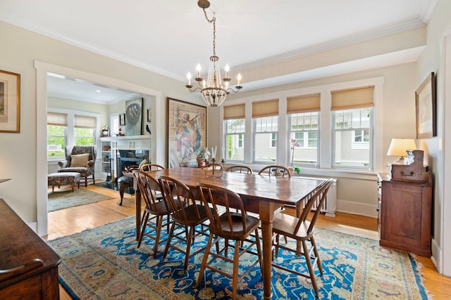 1040 Shermer Rd, Northbrook, IL 60062 - dining room featuring ornamental molding, a chandelier, light wood finished floors, a warm lit fireplace, and baseboards