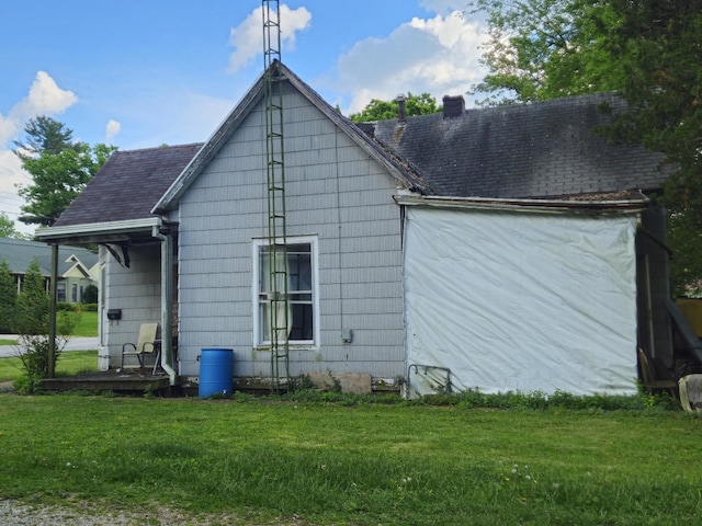 926 Division St, Charleston, IL 61920 - back of house featuring a chimney, a lawn, and roof with shingles