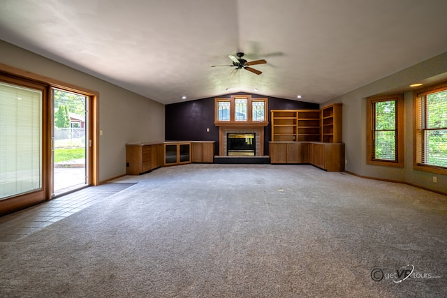 2031 W Winchester Dr, Freeport, IL 61032 - unfurnished living room featuring lofted ceiling, ceiling fan, a glass covered fireplace, carpet flooring, and baseboards