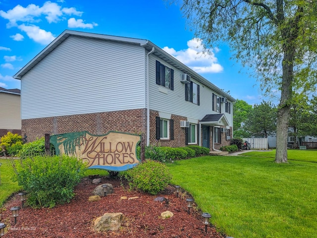 370 Echo Ln Unit 3, Aurora, IL 60504 - view of home's exterior with a yard, brick siding, and a wall unit AC