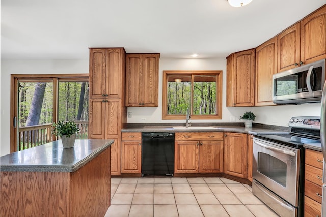 2030 Burke Dr, Winthrop Harbor, IL 60096 - kitchen with stainless steel appliances, a sink, dark countertops, and brown cabinetry