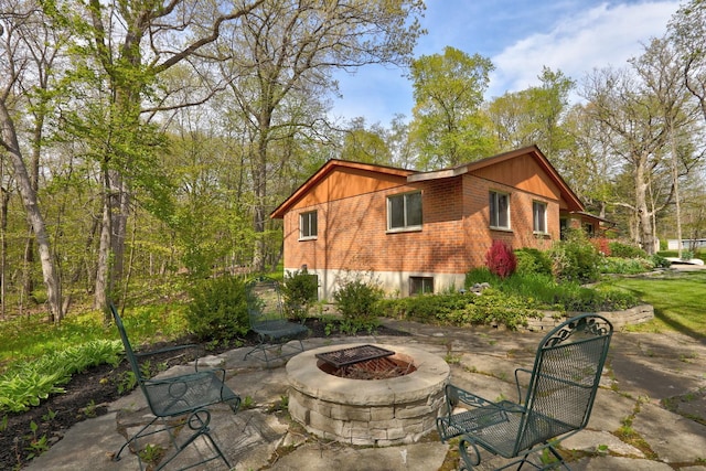 2030 Burke Dr, Winthrop Harbor, IL 60096 - view of side of property with an outdoor fire pit, brick siding, and a patio