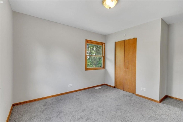 unfurnished bedroom with carpet, baseboards, and a closet