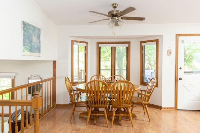 dining area with light wood finished floors, healthy amount of natural light, and baseboards