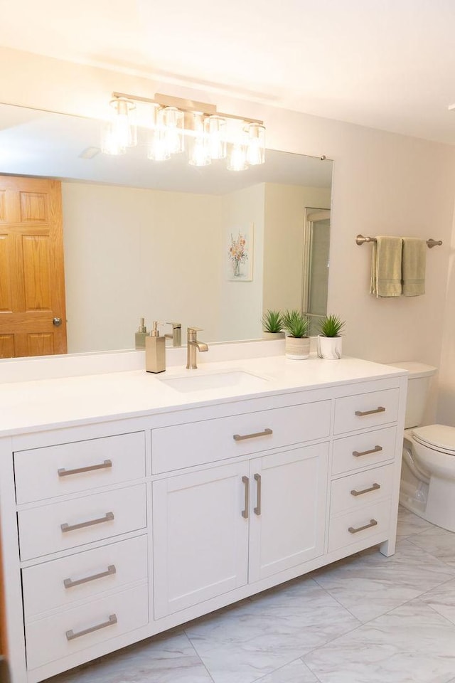 full bathroom with marble finish flooring, toilet, and vanity
