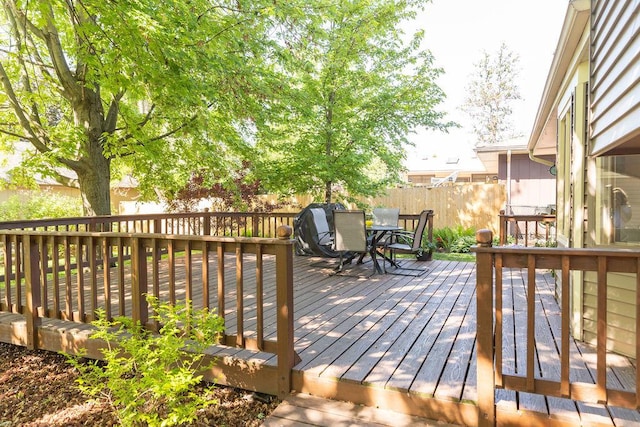 wooden terrace featuring outdoor dining space and a fenced backyard