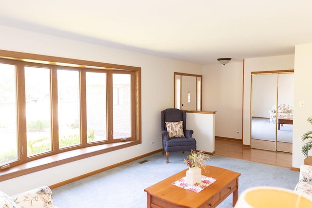 living area with baseboards and carpet