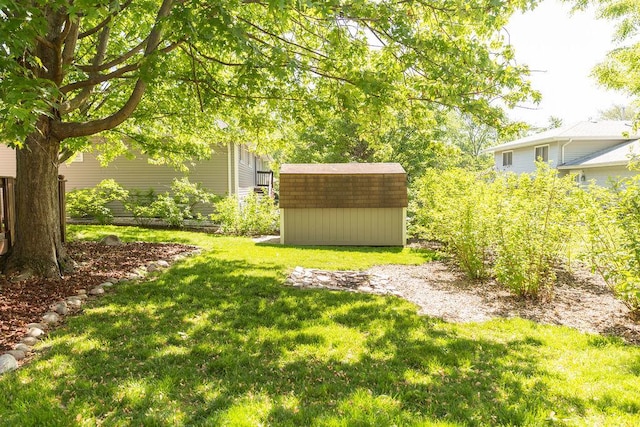 view of grassy yard featuring a storage unit and an outdoor structure