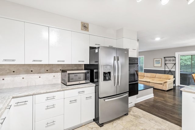2S579 Partridge Rd, Batavia, IL 60510 - kitchen with appliances with stainless steel finishes, white cabinets, tasteful backsplash, open floor plan, and light stone counters