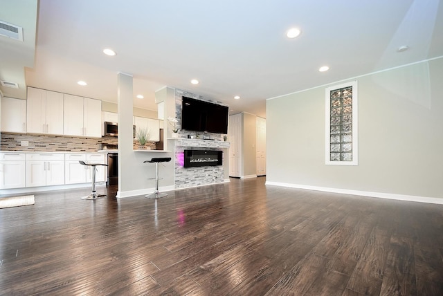 1103 S Hunt Club Dr Unit 127, Mount Prospect, IL 60056 - unfurnished living room featuring dark wood-style floors, recessed lighting, baseboards, and a stone fireplace