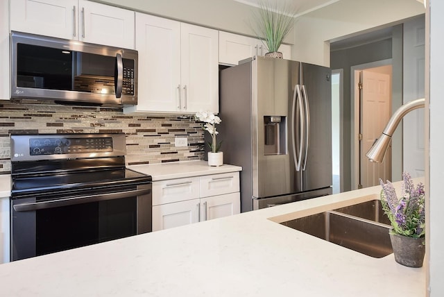 1103 S Hunt Club Dr Unit 127, Mount Prospect, IL 60056 - kitchen featuring stainless steel appliances, a sink, light countertops, white cabinets, and decorative backsplash