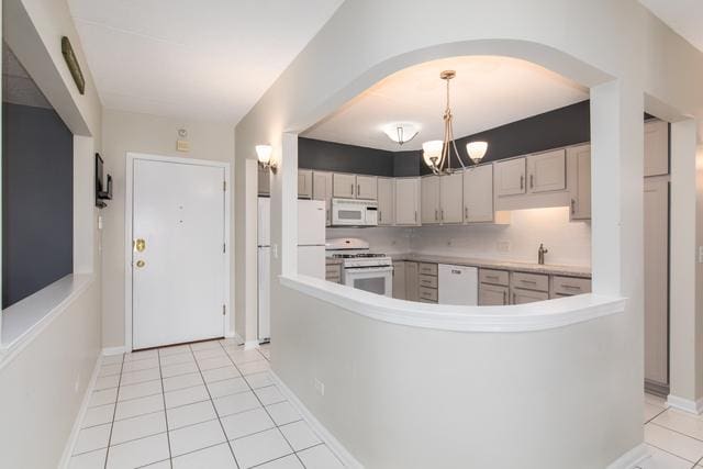 400 S NW Hwy Unit 309, Park Ridge, IL 60068 - kitchen with white appliances, a chandelier, arched walkways, light tile patterned floors, and light countertops
