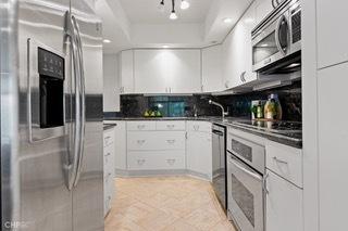 1430 N Astor St Unit 7A, Chicago, IL 60610 - kitchen with appliances with stainless steel finishes, white cabinetry, dark countertops, and backsplash