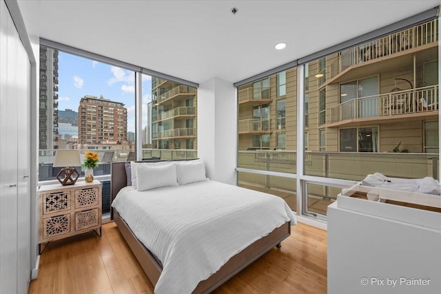 653 N Kingsbury St Unit 706, Chicago, IL 60654 - bedroom featuring a view of city, wood finished floors, recessed lighting, and floor to ceiling windows