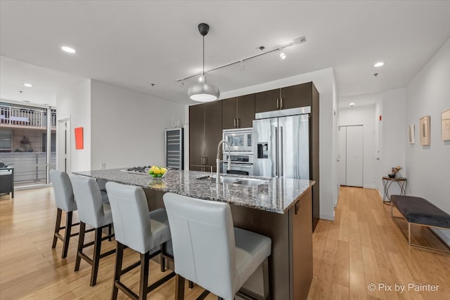 653 N Kingsbury St Unit 706, Chicago, IL 60654 - kitchen featuring stainless steel appliances, a sink, wine cooler, a kitchen bar, and light wood-type flooring