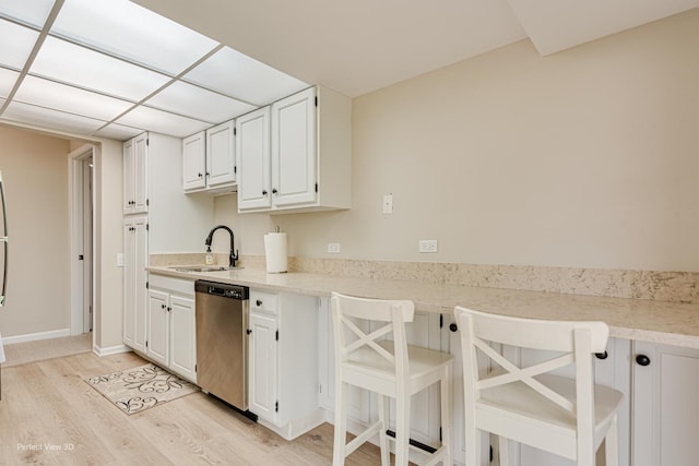 2 S Atrium Way Unit 407, Elmhurst, IL 60126 - kitchen featuring a sink, stainless steel dishwasher, light wood-style flooring, and a breakfast bar