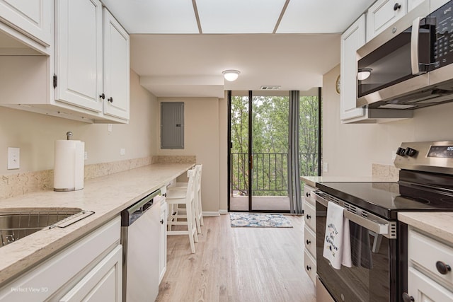 2 S Atrium Way Unit 407, Elmhurst, IL 60126 - kitchen featuring appliances with stainless steel finishes, expansive windows, white cabinets, electric panel, and light wood-style flooring