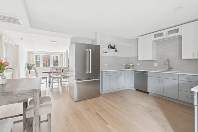 2534 W Haddon Ave, Chicago, IL 60622 - kitchen with stainless steel appliances, a sink, light countertops, light wood finished floors, and tasteful backsplash