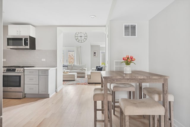 2534 W Haddon Ave, Chicago, IL 60622 - kitchen with appliances with stainless steel finishes, light wood-type flooring, tasteful backsplash, light countertops, and baseboards