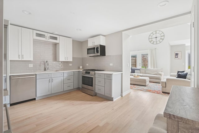 2534 W Haddon Ave, Chicago, IL 60622 - kitchen with appliances with stainless steel finishes, a sink, gray cabinetry, decorative backsplash, and light wood-style flooring