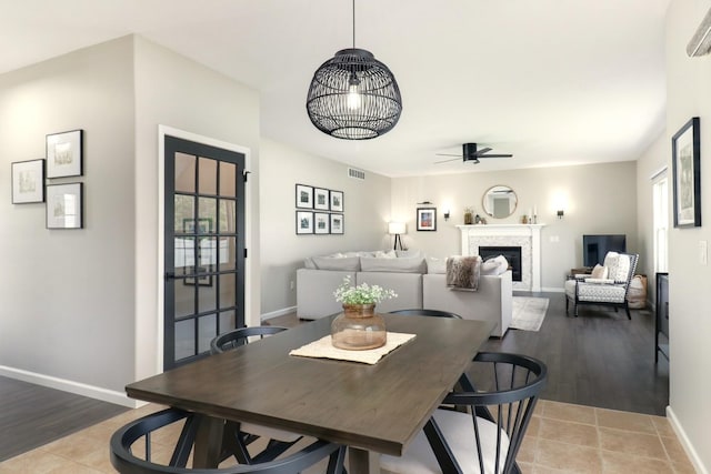 1811 Partridge Pt, Normal, IL 61761 - dining room featuring a ceiling fan, baseboards, a fireplace, light wood-style floors, and healthy amount of natural light