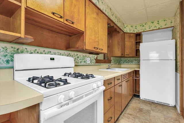 235 N Main St, Roberts, IL 60962 - kitchen featuring white appliances, a sink, light countertops, brown cabinetry, and wallpapered walls