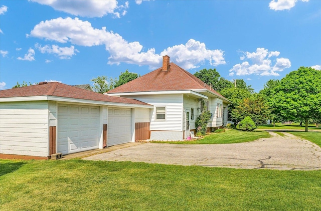 235 N Main St, Roberts, IL 60962 - view of property exterior featuring a chimney, an outdoor structure, driveway, and a yard